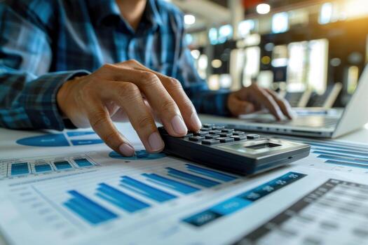 A person is using a calculator to add numbers on a piece of paper photo