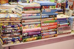 New Delhi, India, June 17 2024 - Variety of Books on shelf inside a book-stall at Delhi International Book Fair, Selection of books on display in Annual Book Fair at Bharat Mandapam complex photo
