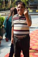 New Delhi, India - May 25 2024 - Unidentified people showing their ink-marked fingers after casting votes in front of polling booth of east Delhi area for general Lok Sabha Elections 2024 photo
