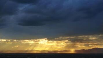 Sunset in the mountains with sun rays and clouds photo