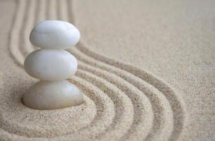 White zen stones on sand with customizable space for text photo
