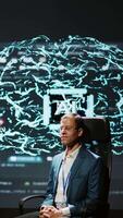 Vertical Company CEO using summit as platform to launch latest AI EEG headset product. Neuroscientist doing demonstration at forum in front of business leaders interested in artificial intelligence, camera B video