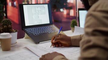 Corporate owner measuring and evaluating office blueprints and architectural sketches, working on strategy planning for a modern and professional workspace design. Relocate office space. Camera B. video