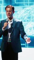 Vertical Upbeat presenter inviting engineer on stage during global IT conference to talk about subjects such as enterprise AI, deep learning, big data, neural networks and cognitive computing, camera A video