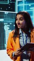 Vertical Public speaker doing presentation at tech forum event, explore ways emerging AI technologies can positively enhance companies workforce. Indian woman promoting artificial intelligence solutions video