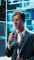 Vertical Speaker does presentation during tech conference, exploring successful implementation of AI in driving forward startup businesses, sharing latest machine learning discoveries, camera B video
