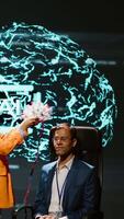 Vertical Company CEO using summit as platform to launch latest AI EEG headset product. Neuroscientist doing demonstration at forum in front of business leaders interested in artificial intelligence, camera A video