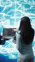Vertical Coworkers doing brainstorming, using devices to fix artificial intelligence neural networks. High tech workspace colleagues using AI system aiding in processing and transmitting information, camera B video