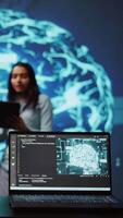 Vertical Focus on laptop in workspace used by AI researchers working with artificial intelligence in blurry background. Close up of notebook used by employees developing AI systems in tech startup, camera B video