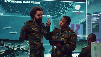Diverse team of army officers reviewing important information from the enemy lines, ensuring advantage in a military command center. People using satellite surveillance in power base. Camera A. video