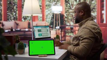 Financial expert reviews business statistics next to a chroma key screen, analyzing budget balance to ensure a correct economic situation report. Entrepreneur examines data analytics. Camera B. video