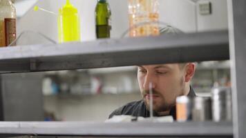 a professional chef inspects all completed orders and makes an inventory of orders in the kitchen in a restaurant. Checking orders in the kitchen to structure the work of cooks video