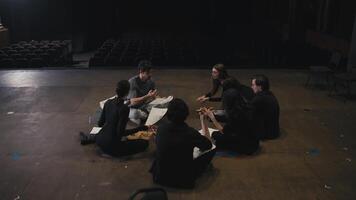 Happy group of actors holding script sheets in their hands and actively discussing their roles with the director on stage in the theater during rehearsal video