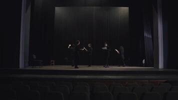 Confident group of young actors in black suits walk in a circle on stage in the theater and read out their words during preparation and rehearsal for a performance in the theater video