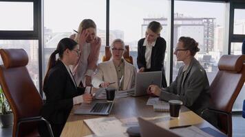 Side view of a confident middle-aged blonde girl in a white business suit communicates with her colleagues during a meeting and listens to their suggestions and ideas while working in the office video