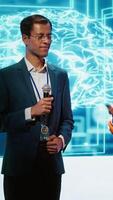 Vertical Tech startup managers offer latest AI services during tech summit. Businesspeople using mic to do presentation for business investors interested in artificial intelligence, camera A video