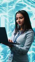 Vertical Technician using laptop to maintenance artificial intelligence neural networks made up of interconnected nodes layers. Admin using AI system aiding in processing and transmitting information, camera A video