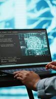 Vertical AI computer scientist using laptop for business data analysis in high tech workspace. Close up shot of Indian woman working on notebook to automatize tasks using artificial intelligence, camera A video