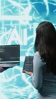 Vertical Team of admins using tablet and laptop to maintenance artificial intelligence neural networks. Teamworking IT staff members using AI system aiding in processing and transmitting information, camera A video