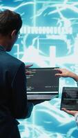 Vertical Coworkers doing brainstorming, using devices to fix artificial intelligence neural networks. High tech workspace colleagues using AI system aiding in processing and transmitting information, camera A video