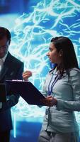 Vertical AI researcher and coworker working with artificial intelligence neural networks. Computer scientists collaborating on developing AI system in high tech workspace, camera B video