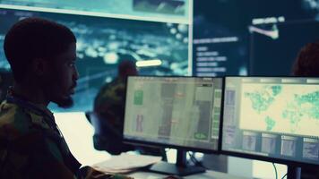 Army officer develops contingency plans to address unexpected developments in the field, studying real time satellite intelligence in military command post. Soldier tracking enemy servers. Camera B. video