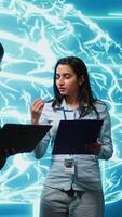Vertical AI researcher and coworker working with artificial intelligence neural networks. Computer scientists collaborating on developing AI system in high tech workspace, camera A video