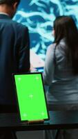Vertical Engineers use green screen tablet and AI neural networks modeled after human brain to solve complex problems. Workers using artificial intelligence and mockup device to look at company data, camera A video