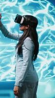 Vertical Developer wearing VR headset looking at hologram of artificial intelligence human brain simulation. Programmer interacting with AI visualization showing machine learning algorithms, camera A video