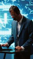 Vertical Engineer in artificial intelligence workplace managing call center tasks, speaking into headset. AI company worker chatting with customers through headphones mic, camera A video