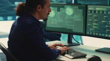 Governmental IT expert monitoring cyber threats on a computer and big screen, high tech agency office. Hackers examining cyber defense measures for prevention of dangerous digital threats. Camera A. video