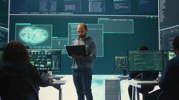 Governmental hackers breaching network security with advanced techniques, cyber defense in action. Team of IT experts working on gaining access to collect information, big screen. Camera B. video