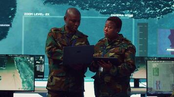 Special operations engineers examining surveillance footage to gather important information for a mission, working on reconnaissance in military headquarters. Army soldiers in command post. Camera A. video
