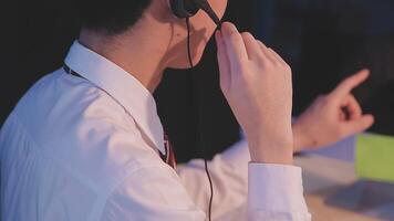 Where would we be without loyal customers like you. Shot of a young man using a headset and computer in a modern office. video