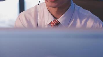 Where would we be without loyal customers like you. Shot of a young man using a headset and computer in a modern office. video