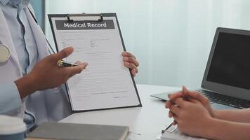 Confident doctor man holding a pill bottle while talking with a senior patient and reviewing his medication at office room. video