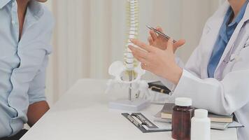Orthopedists holding digital tablet and pointing at model. Concept of osteoporosis, back pain, lumbar, chiropractic and health. video