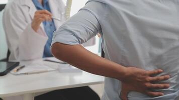 Orthopedists holding digital tablet and pointing at model. Concept of osteoporosis, back pain, lumbar, chiropractic and health. video