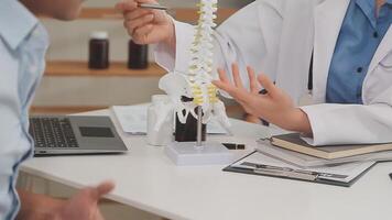 Orthopedists holding digital tablet and pointing at model. Concept of osteoporosis, back pain, lumbar, chiropractic and health. video