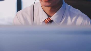 Where would we be without loyal customers like you. Shot of a young man using a headset and computer in a modern office. video