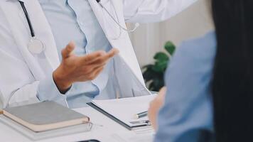 Confident doctor man holding a pill bottle while talking with a senior patient and reviewing his medication at office room. video