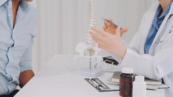 Orthopedists holding digital tablet and pointing at model. Concept of osteoporosis, back pain, lumbar, chiropractic and health. video