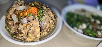 Giant Bakso, or Jumbo meatball is indonesian meatball style served with beef broth soup and noodle springkled with fried onion and spring onion coupled with chili sauce on the top photo