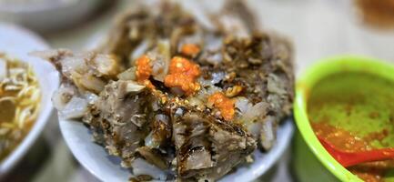 Giant Bakso, or Jumbo meatball is indonesian meatball style served with beef broth soup and noodle springkled with fried onion and spring onion coupled with chili sauce on the top photo