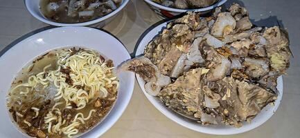 Giant Bakso, or Jumbo meatball is indonesian meatball style served with beef broth soup and noodle springkled with fried onion and spring onion coupled with chili sauce on the top photo