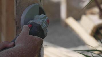 A man is using a power tool to cut wood. Concept of productivity and hard work. Slow motion video