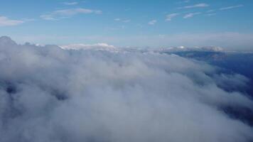 Aerial view. High above thick fog, like beautiful ocean of clouds at sunrise. Sun is rising above the endless sea of clouds until the horizon. Amazing nature landscape. Climate and weather change video