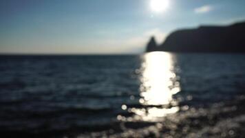 Abstract nature summer or spring ocean sea background. Small waves on golden warm water surface in motion blur with bokeh lights from sunrise. Holiday, vacation and recreational background concept video