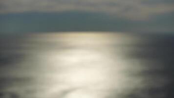 Abstract nature summer or spring ocean sea background. Small waves on golden warm water surface in motion blur with bokeh lights from sunrise. Holiday, vacation and recreational background concept video