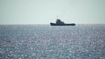 Tug boat in open calm sea, heading back to port at sunset, helps large container ships maneuver. Aerial view, maritime industry, oceanic transportation or business concepts. video